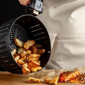 French Fries being poured out on table from air fryer basket