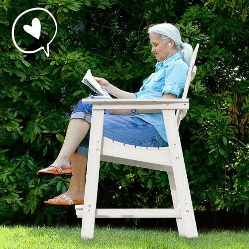 Woman sitting in tall Adirondack chair reading