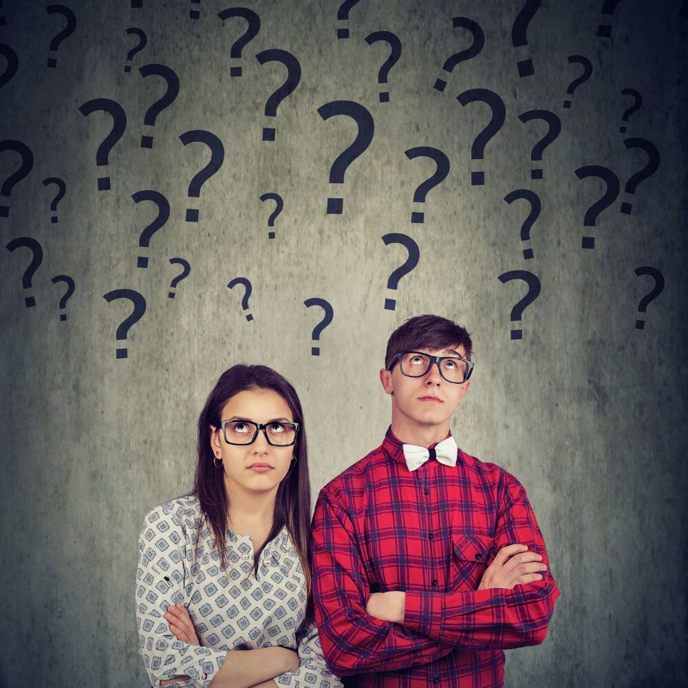 Two people with arms folded and questioning expressions with question marks floating over their heads.