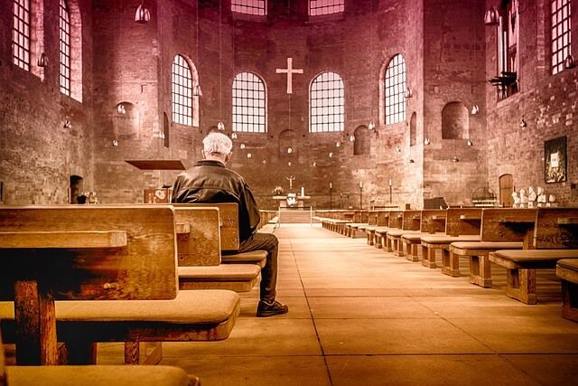 Man sitting in sanctuary of church praying
