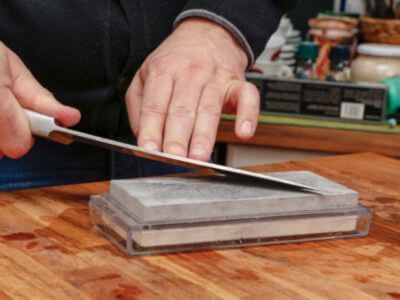 Example of sharpening stone - man sharpening a knife blace