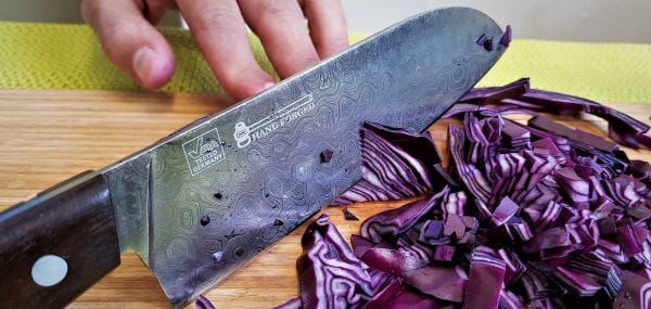 Damascus knife chopping purple cabbage