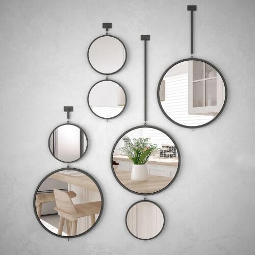 Series of different sized round mirrors decorating a wall